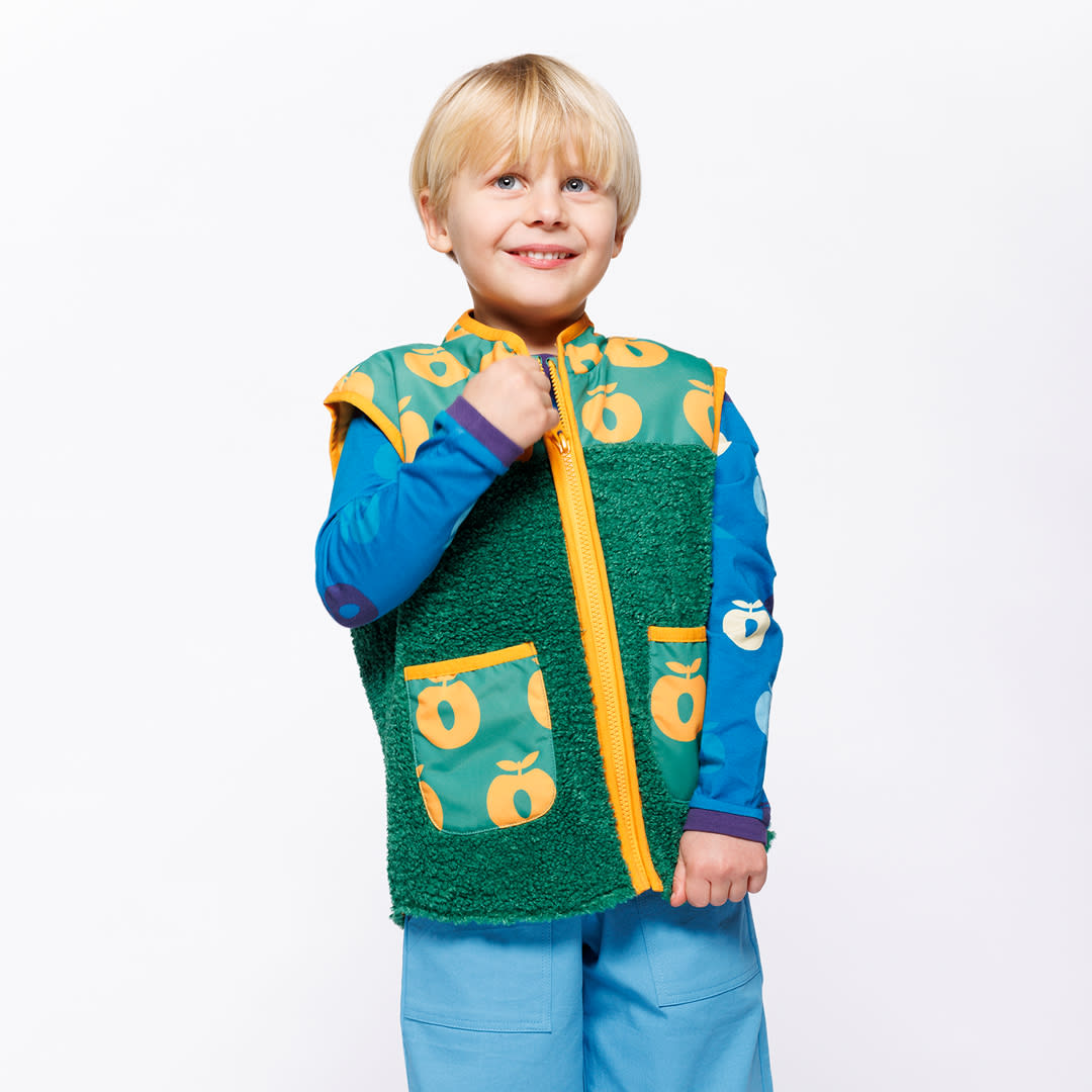 Dreng med grøn vest med orange æbler