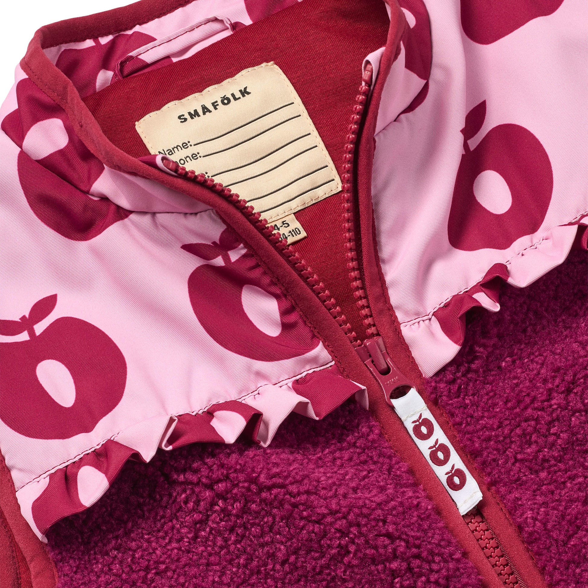 Nærbillede af lynlås på lyserød vest